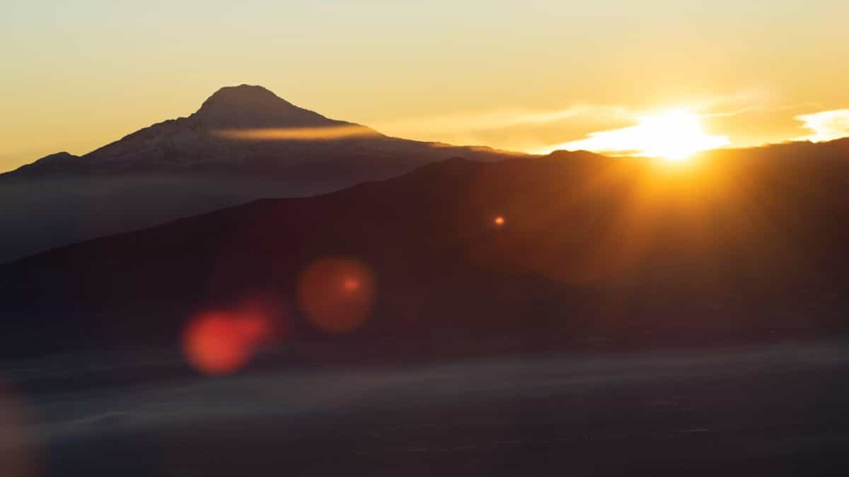 El coloso Cayambe recibiendo los primeros rayos del sol, mientras Quito aún permanece envuelto en helada y espesa neblina.